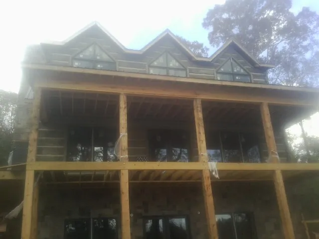 Dormers and porch framing on a large log home under construction — Roof Coating work by our crew in Newberg